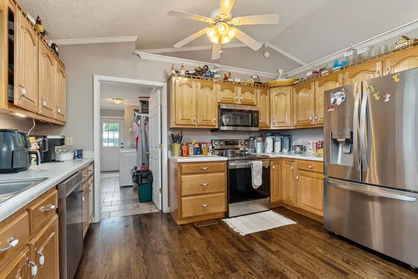 a kitchen with granite countertop a sink cabinets and wooden floor