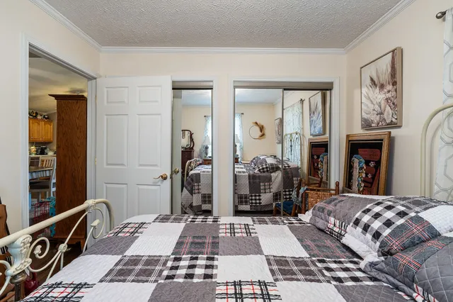 a bedroom with a bed a large window and a table