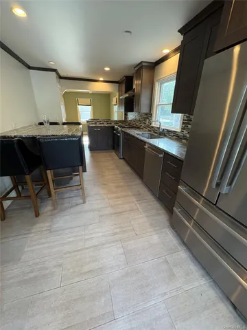 a kitchen with stainless steel appliances kitchen island granite countertop a sink counter space and cabinets