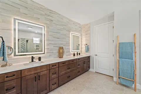 a bathroom with a granite countertop sink a toilet a mirror and shower