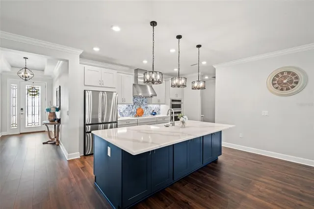 a kitchen with stainless steel appliances kitchen island granite countertop a sink and a stove with white countertops