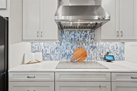 a kitchen with stainless steel appliances kitchen island granite countertop a sink a counter top space and living room view