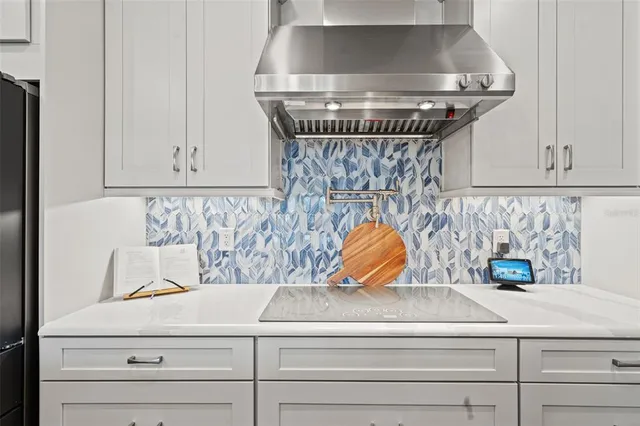 a kitchen with stainless steel appliances kitchen island granite countertop a sink a counter top space and living room view