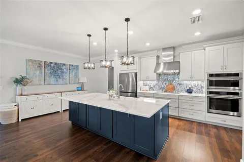 a kitchen with stainless steel appliances granite countertop a refrigerator and a stove top oven
