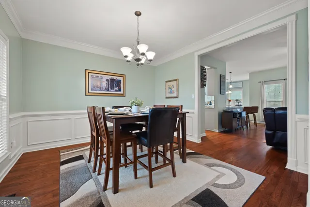 a view of a dining room with furniture wooden floor and chandelier