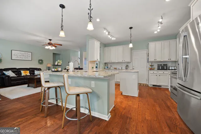 a kitchen with stainless steel appliances kitchen island hardwood floor sink and stove