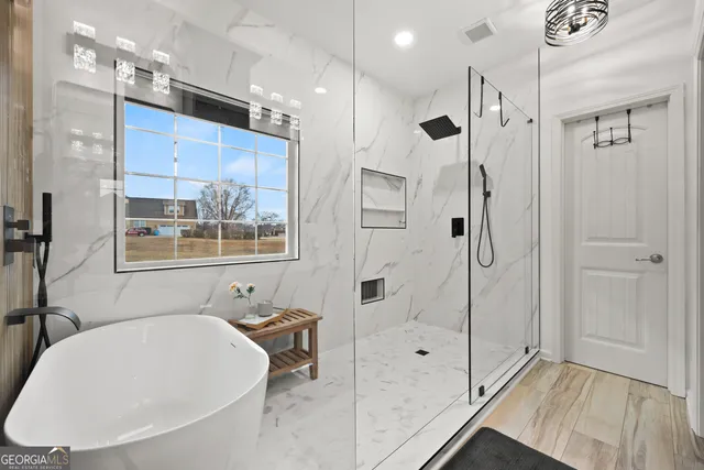 a bathroom with a tub shower sink and mirror
