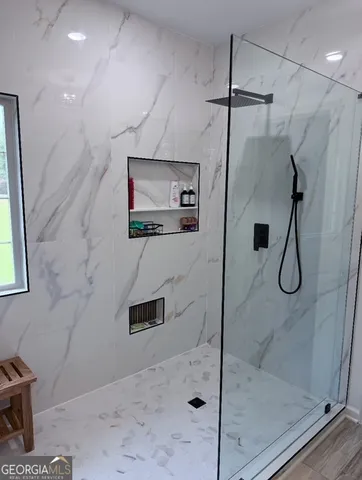 a bathroom with a shower and a glass door