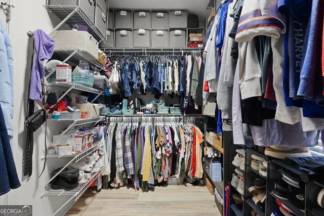 a view of walk in closet with clothes