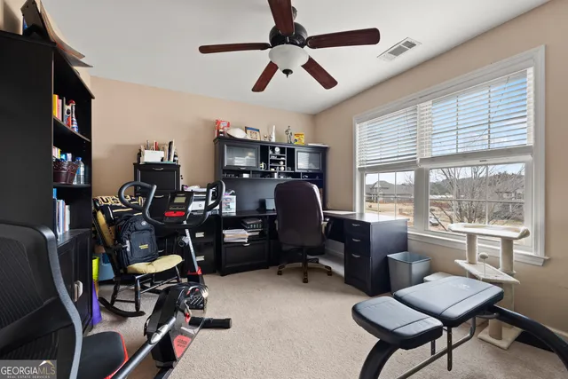 a view of a workspace with furniture and a window