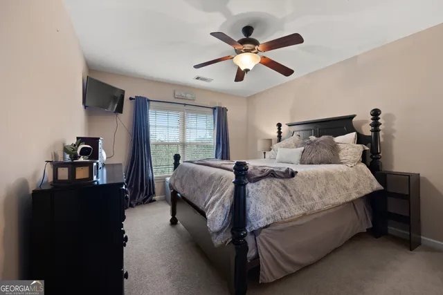 a spacious bedroom with a bed and a chandelier
