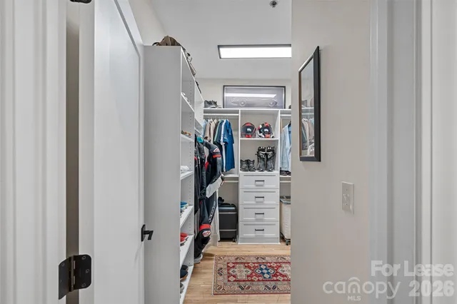 a view of walk in closet with clothes and shoes