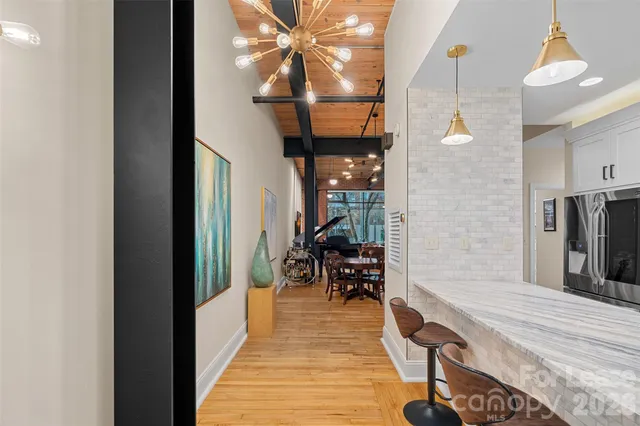 a kitchen with stainless steel appliances granite countertop a sink a microwave a refrigerator and white cabinets