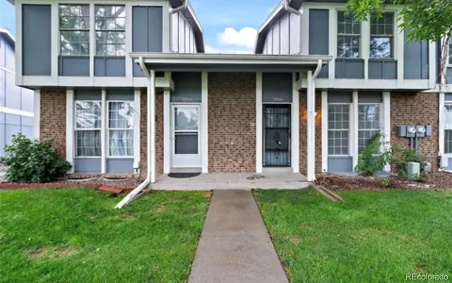 a front view of brick house with a yard