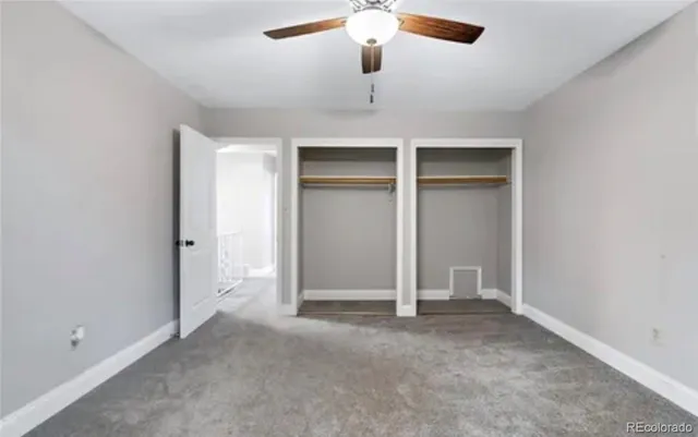 an empty room with chandelier fan