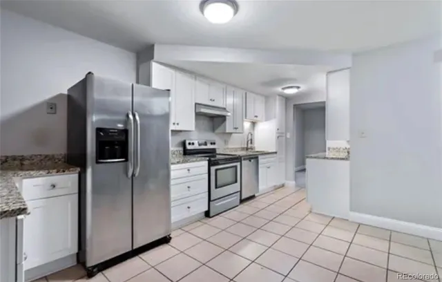 a kitchen with a refrigerator sink and cabinets