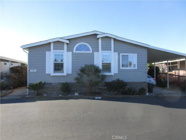 a front view of a house with yard and parking
