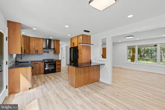 a kitchen with kitchen island a counter top space a sink stainless steel appliances and cabinets