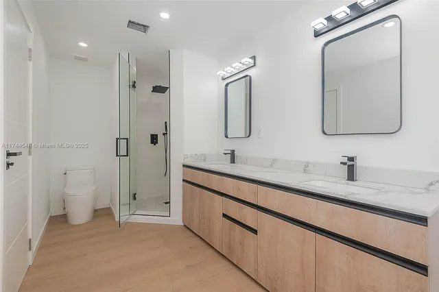 a spacious bathroom with a double vanity sink mirror and toilet