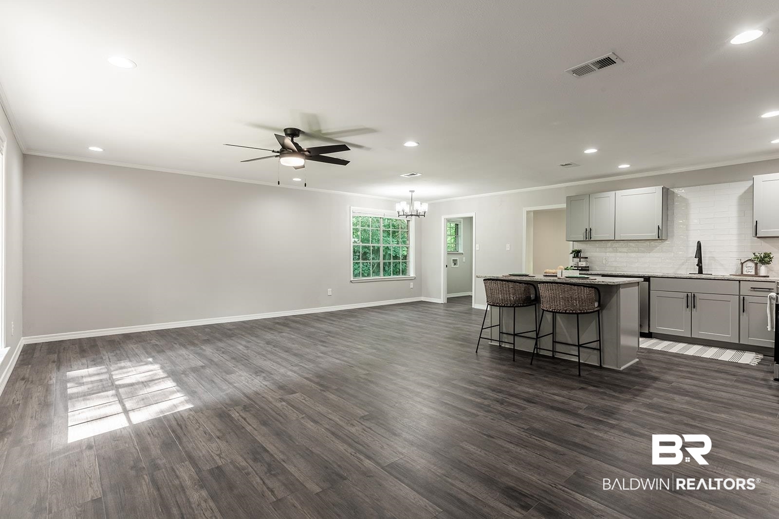 4626 Gold Drive Mobile, AL 36619 - Photo 11 of 48 Kitchen featuring a breakfast bar, dark wood-type flooring, backsplash, ceiling fan with notable chandelier, and a kitchen island