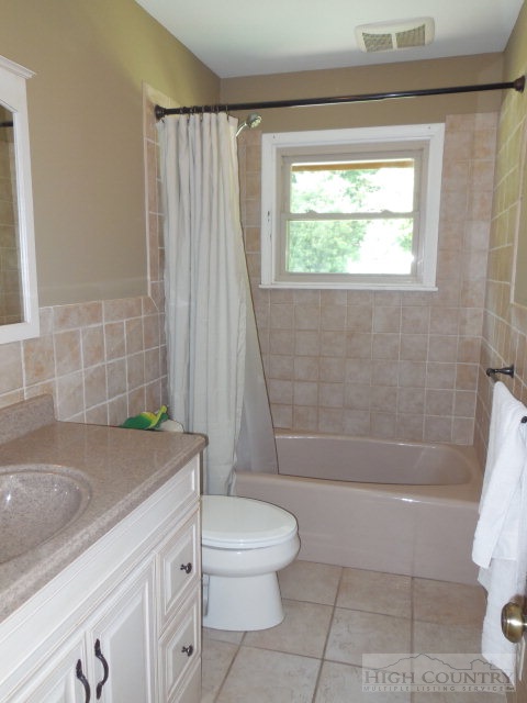 378 Howard's Creek Road Boone, NC 28607 - Photo 15 of 35 a bathroom with a granite countertop sink a toilet and bathtub