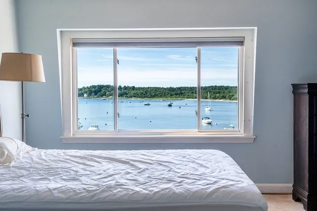 a view of a bedroom with a bed and a window
