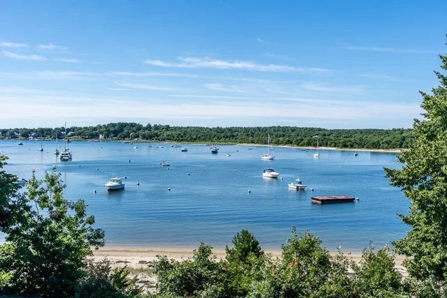 aerial view of a house with outdoor space and lake view in back