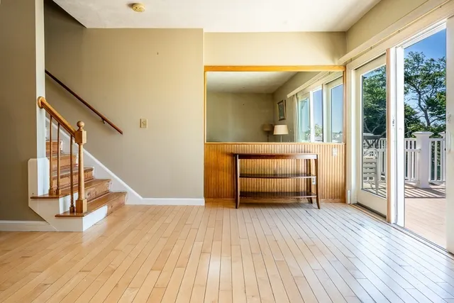 a view of a hallway with wooden floor and furniture