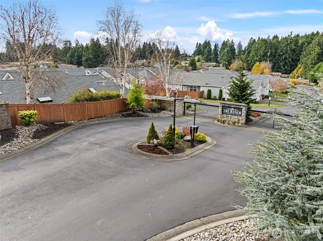 a view of a white house next to a yard and large trees