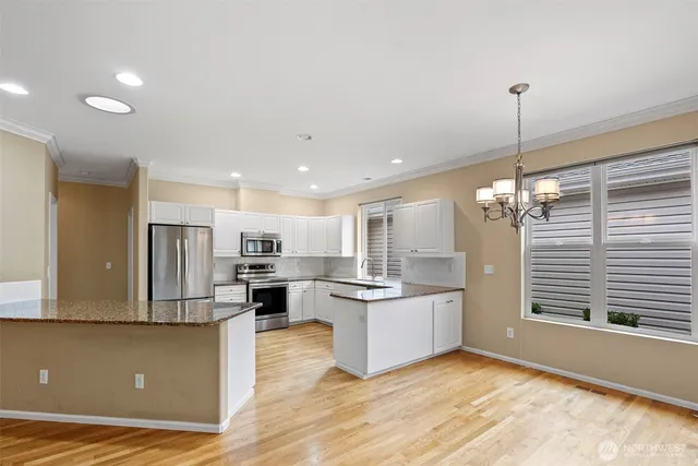 a kitchen with kitchen island a stove a sink and a refrigerator