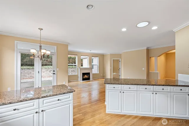 a large kitchen with granite countertop a large window and white appliances