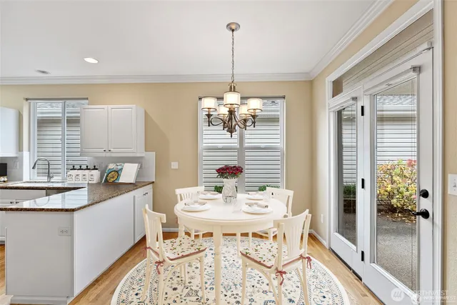 a kitchen with a dining table chairs and white cabinets