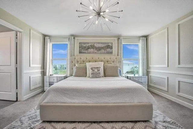 a bedroom with a large bed and a chandelier