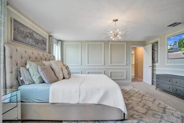 a bedroom with a large bed and a chandelier