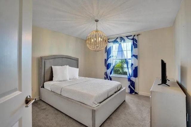 a bedroom with a bed and a chandelier