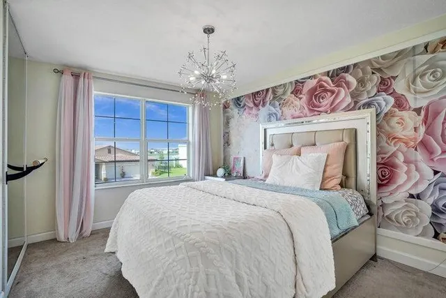 a spacious bedroom with a large bed and a chandelier