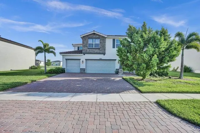 a front view of a house with a yard and a garage