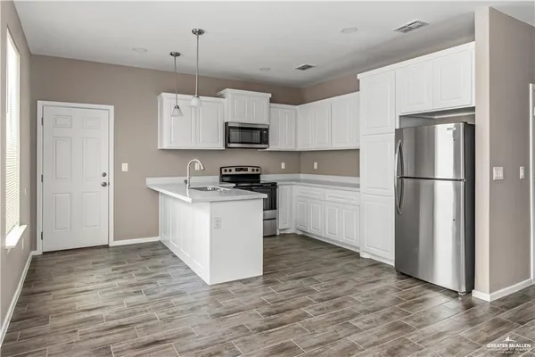 a kitchen with white cabinets and stainless steel appliances