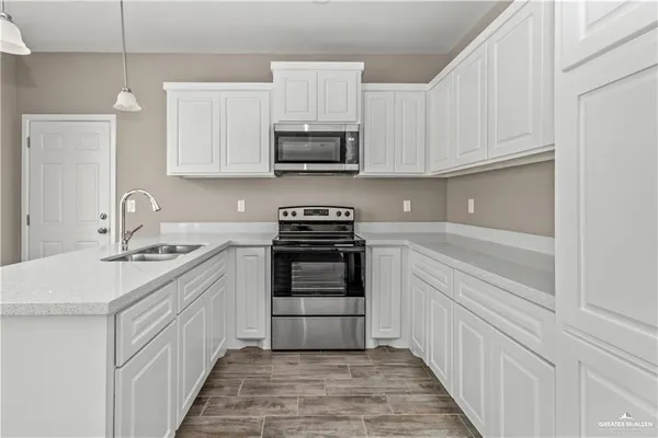 a kitchen with stainless steel appliances granite countertop a sink and a stove
