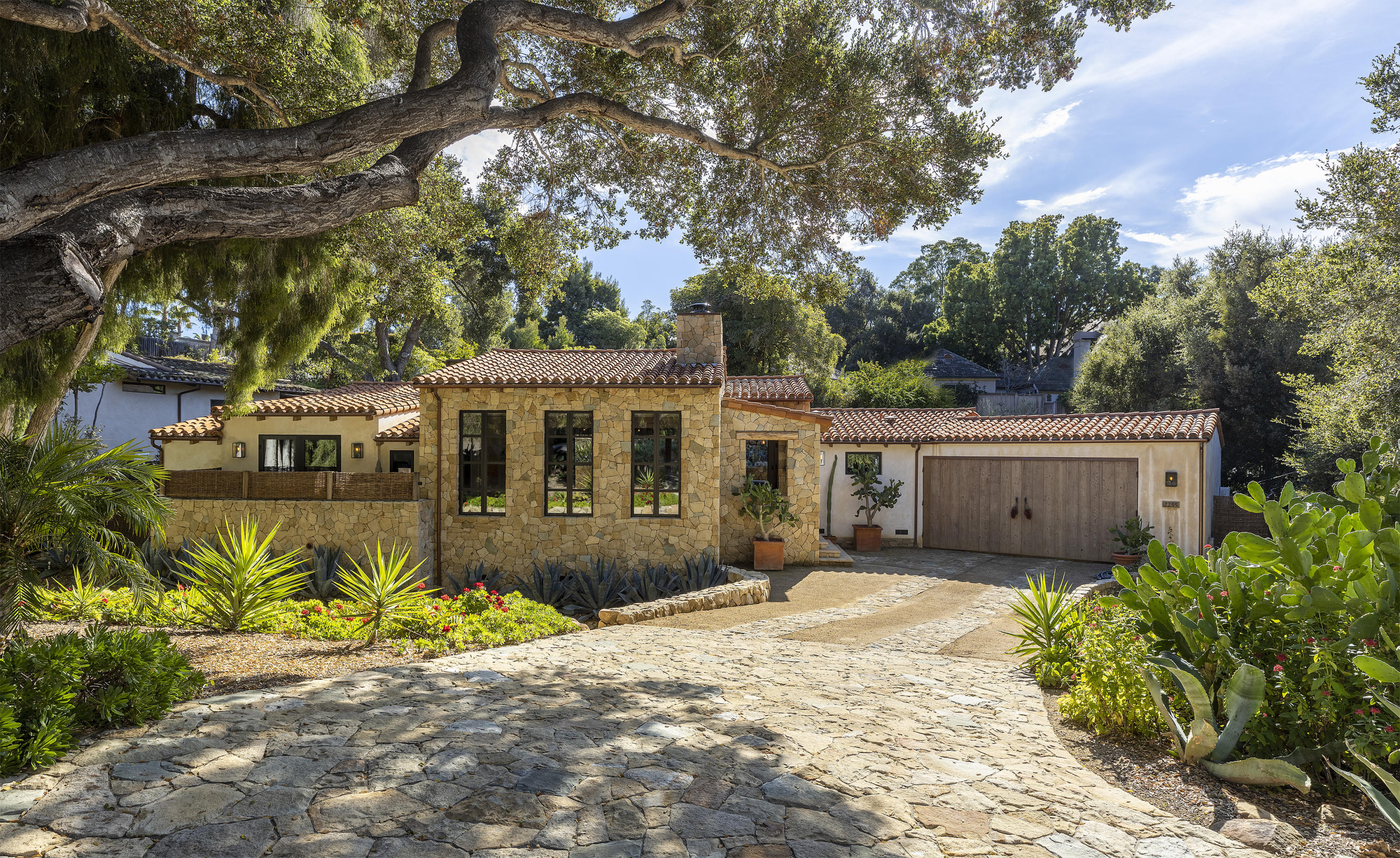 a front view of a house with a garden and yard