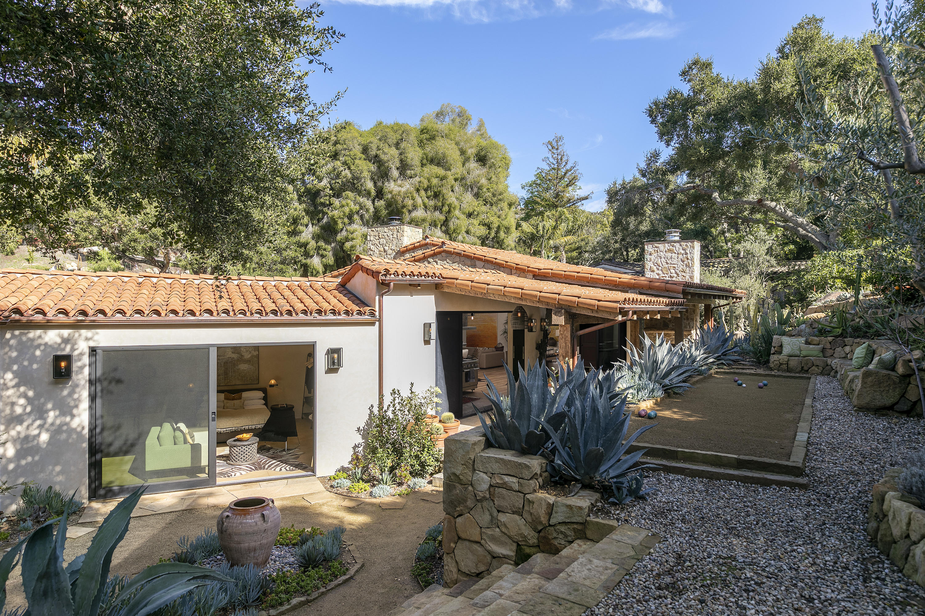 2255 Las Tunas Road Santa Barbara, CA 93103 - Photo 9 of 9 a view of a patio with table and chairs under an umbrella with large trees