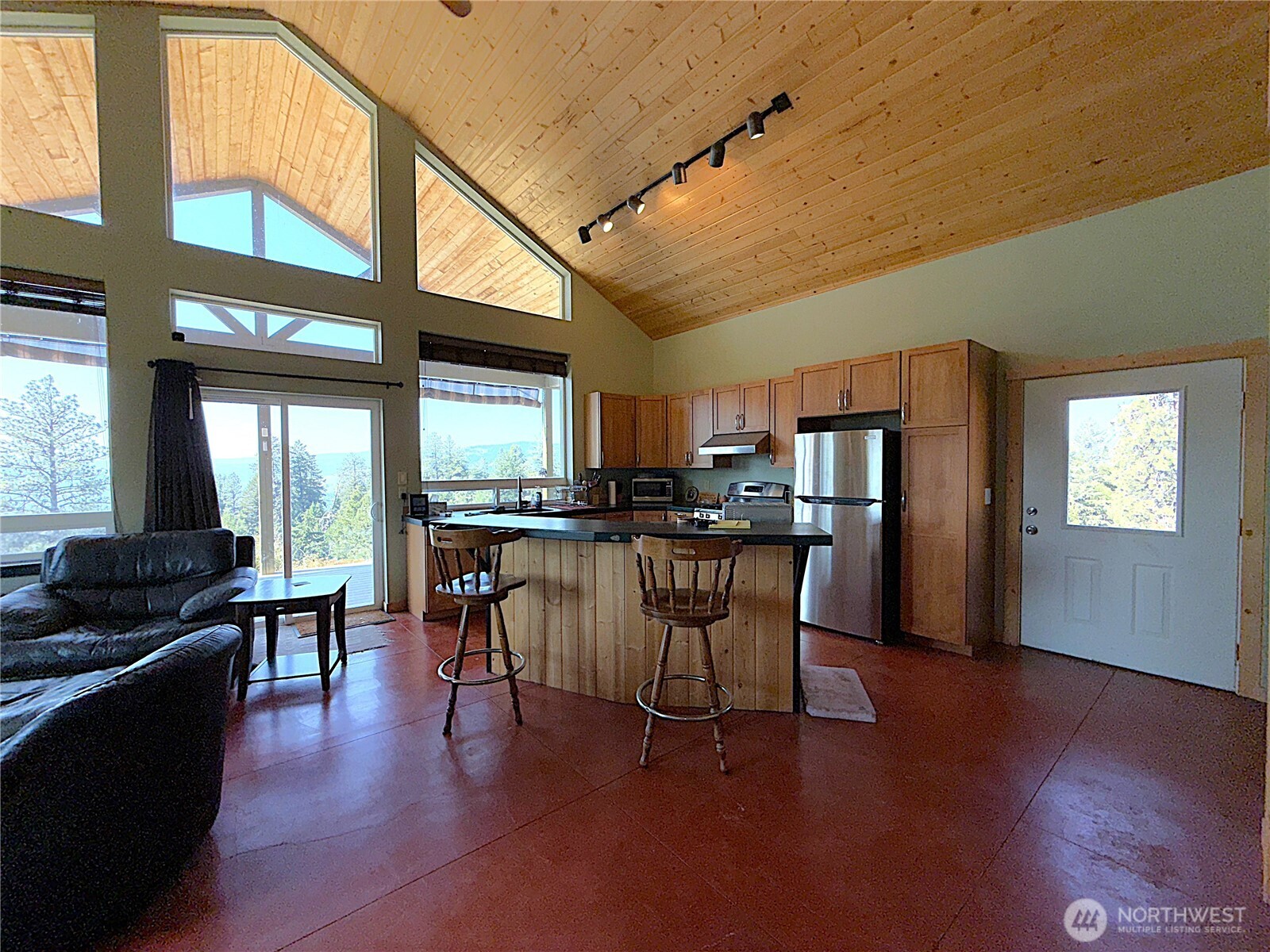 167 Excelsior Way Curlew, WA 99118 - Photo 4 of 37 a kitchen with stainless steel appliances kitchen island granite countertop a refrigerator a stove a dining table and chairs with wooden floor
