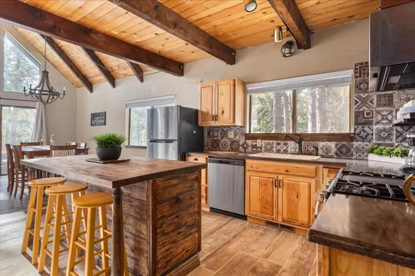 a kitchen with stainless steel appliances granite countertop a sink a stove and a wooden floors