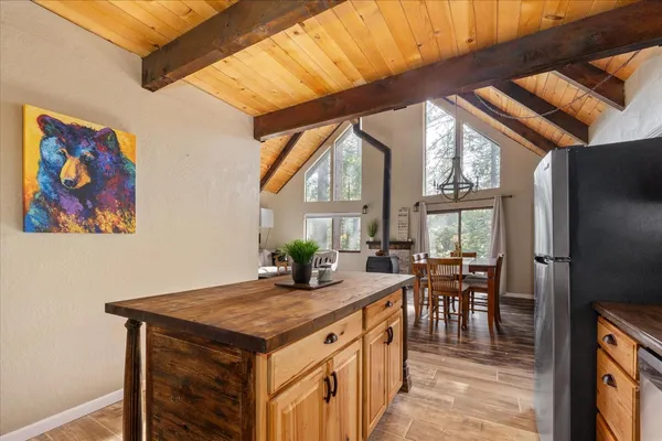 an open kitchen with granite countertop a stove and white cabinets