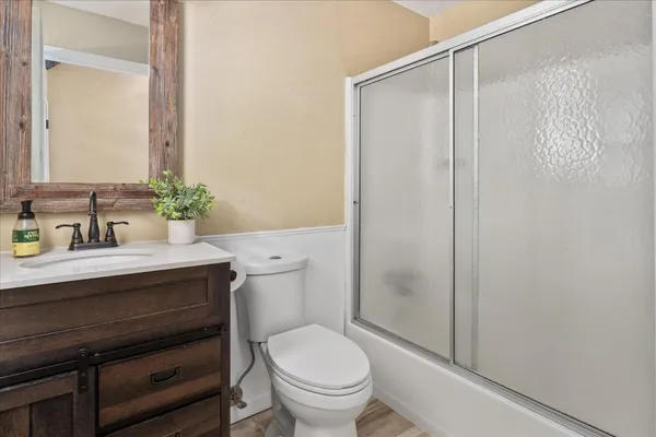 a bathroom with a sink a toilet a mirror and shower