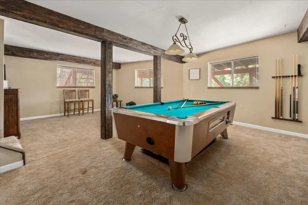 a room with pool table and windows
