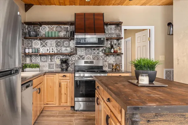 a kitchen with stainless steel appliances granite countertop a stove a sink and a microwave