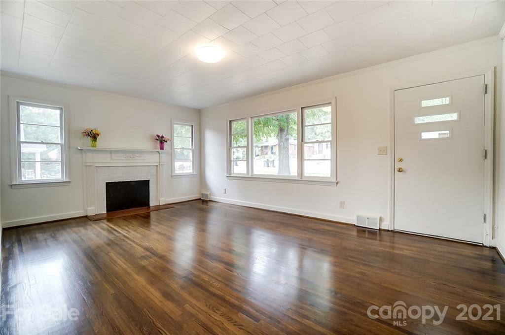 201 Lydia Street Monroe, NC 28110 - Photo 19 of 39 an empty room with wooden floor fireplace and windows