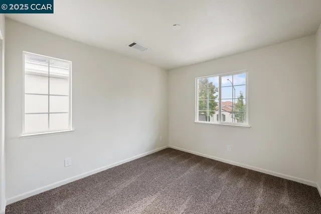 an empty room with windows and closet