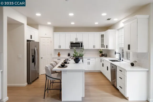 a kitchen with white cabinets and stainless steel appliances
